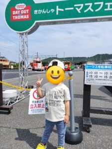 トーマスフェアを背景に写真を撮る息子